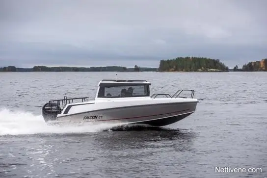 A white Falcon C7 boat speeds across a calm lake with green islands in the background under a cloudy sky.